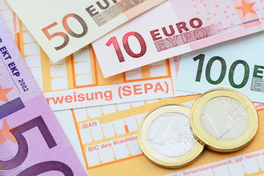 Euro-Banknoten und Münzen auf einem SEPA-Überweisungsformular – Symbolbild für Geldtransfer, Finanzen und Zahlungsverkehr in Europa.